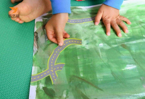 先让孩子在一张大的白纸上面涂上绿色的底色